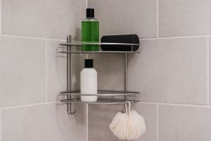 Montering av en elegant svart duschhylla i ett modernt badrum.