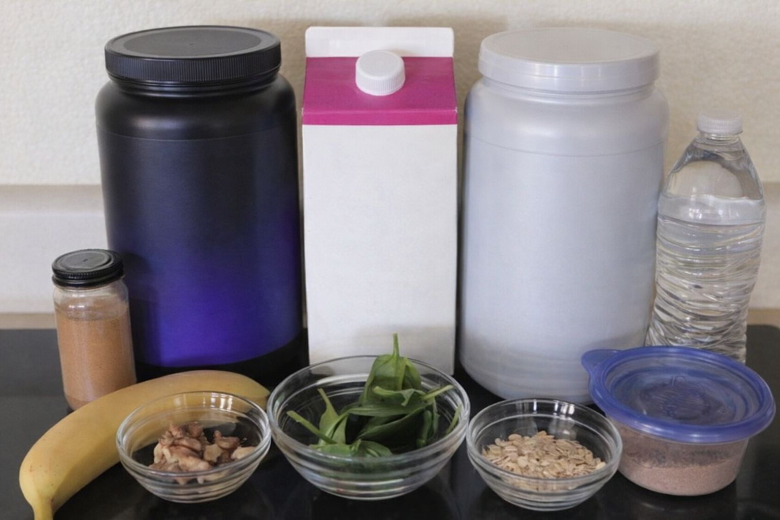 Olika ingredienser och tillskott för en proteinshake, inklusive pulver, mjölk, frukt och grönt.